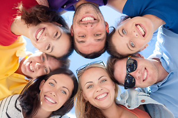 Image showing smiling friends in circle on summer beach