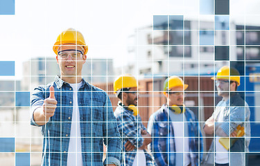 Image showing group of smiling builders in hardhats outdoors