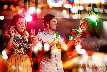 Image showing smiling friends with wine glasses and beer in club