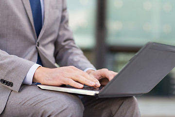 Image showing close up of business man with laptop in city