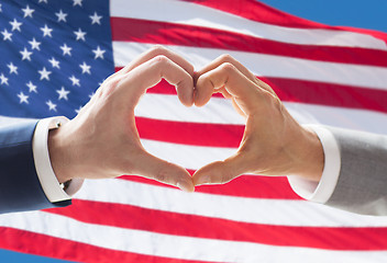 Image showing close up of male gay couple hands showing heart