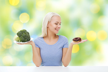 Image showing smiling woman with broccoli and donut