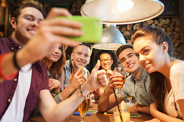 Image showing happy friends with smartphone taking selfie at bar