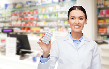 Image showing woman pharmacist with pills drugstore or pharmacy