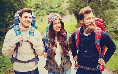 Image showing group of smiling friends with backpacks hiking