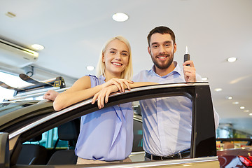 Image showing happy couple buying car in auto show or salon