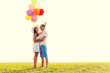 Image showing smiling couple with air balloons outdoors