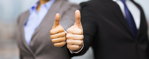 Image showing businessman and businesswoman showing thumbs up