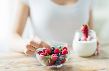 Image showing close up of woman hands with yogurt and berries