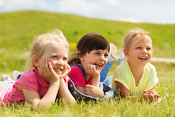 Image showing group of kids lying on blanket or cover outdoors