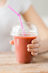 Image showing close up of woman holding cup with smoothie