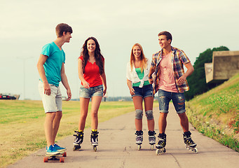 Image showing group of smiling teenagers with roller-skates