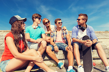 Image showing group of smiling friends sitting on city street