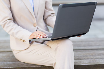 Image showing close up of business woman with laptop in city