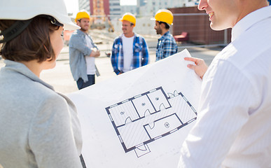 Image showing close up of architects with blueprint at building