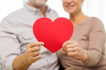 Image showing close up of happy senior couple holding red heart