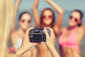 Image showing close up of smiling women photographing on beach