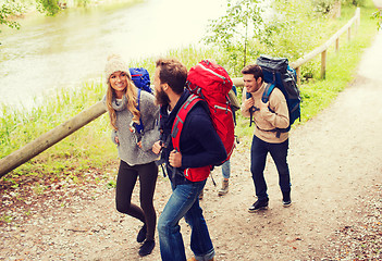 Image showing group of smiling friends with backpacks hiking