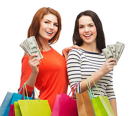 Image showing smiling teenage girls with shopping bags and money