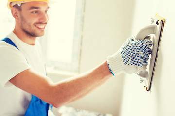 Image showing smiling builder with grinding tool indoors