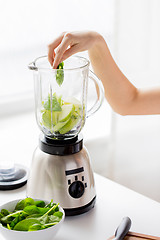 Image showing close up of woman hand with blender and vegetables