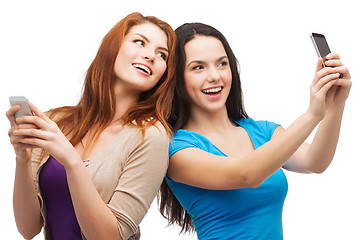 Image showing two smiling teenagers with smartphones