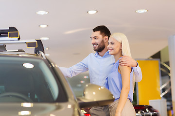 Image showing happy couple buying car in auto show or salon