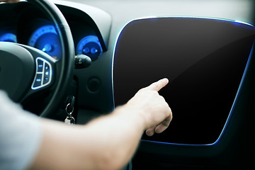 Image showing male hand pointing finger to monitor on car panel