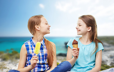 Image showing happy little girls eating ice-cream over beach