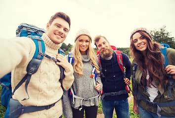 Image showing group of smiling friends with backpacks hiking