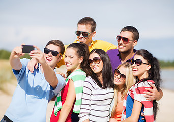 Image showing group of friends taking selfie with cell phone