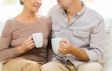 Image showing close up of happy senior couple with cups at home