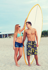 Image showing smiling couple in sunglasses with surfs on beach