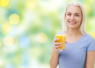 Image showing smiling woman drinking orange juice