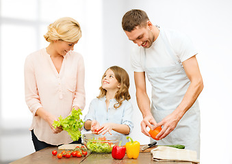 Image showing happy family cooking vegetable salad for dinner