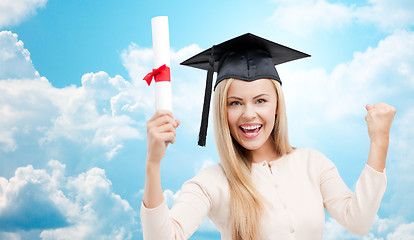 Image showing student in trencher cap with diploma over blue sky