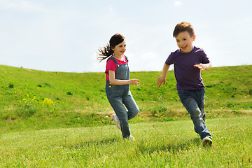 Image showing happy little boy and girl running outdoors