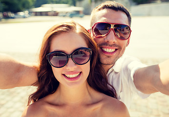 Image showing smiling couple wearing sunglasses making selfie