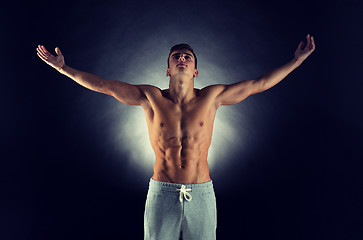 Image showing young male bodybuilder with raised hands