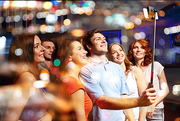 Image showing friends with smartphone taking selfie in club