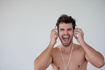 Image showing handsome young man listening music on headphones