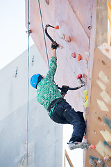 Image showing Man climbs upward on ice climbing competition