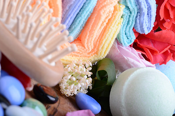 Image showing sea salt, spa stones towels and rose flower petals on wooden table, close up. Relax and treatment therapy. Summer season. 