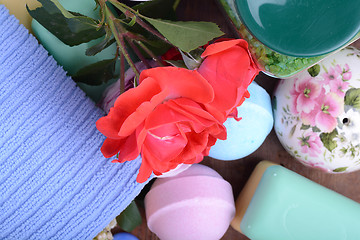 Image showing Spa and wellness setting with sea salt, soap, flowers and towels on wooden background. Relax and treatment therapy. Summer season. Close upq