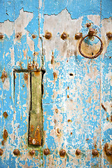 Image showing rusty   paint in the blue wood door and morocco knocker