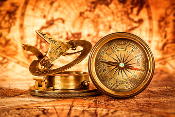 Image showing Vintage compass lies on an ancient world map.