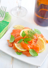 Image showing fresh salmon with lemon on the white plate