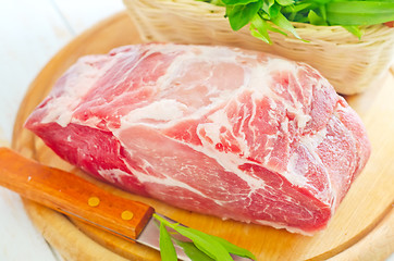 Image showing raw meat and knife on the wooden board