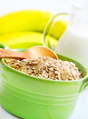 Image showing Oat flakes in the green bowl with banana and milk