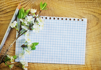 Image showing flowers and note on wooden background